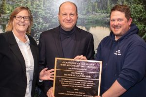 Colorado Governor Jared Polis presents NNL award to Glenwood Caverns and Iron Mountain Hot Springs